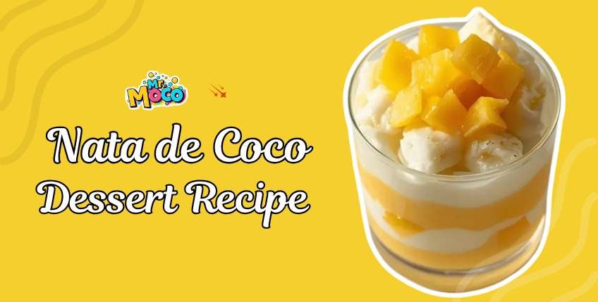 Layered nata de coco dessert with mango puree and translucent coconut jelly cubes in a clear glass, garnished with fresh mango chunks and mint leaves